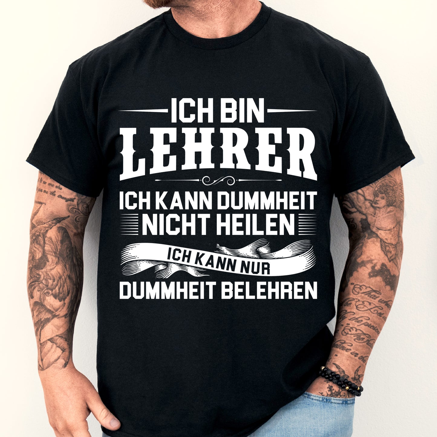 Mann trägt ein humorvolles Lehrer-Shirt mit der Aufschrift "Ich bin Lehrer, kann Dummheit nicht heilen" als Geschenkidee für Lehrer.