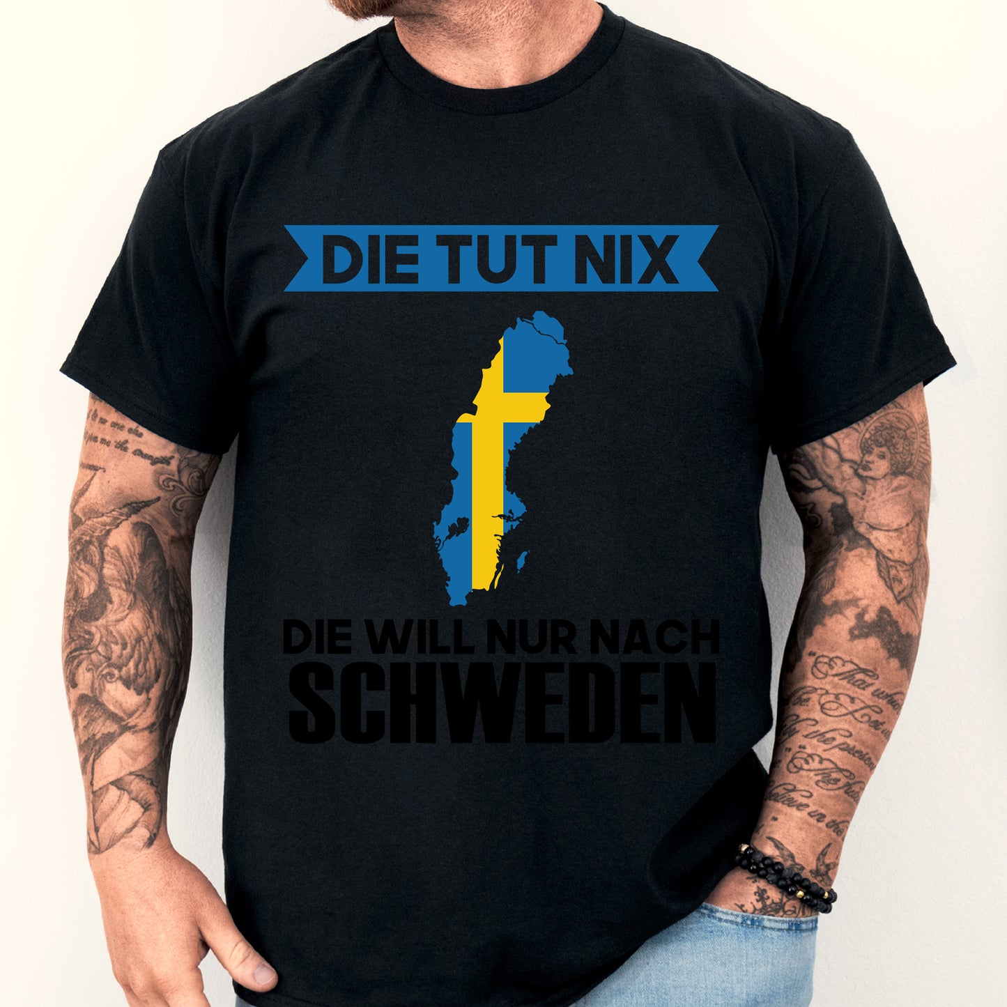 Mann trägt ein blau-gelbes T-Shirt mit schwedischem Design und humorvollem Spruch.