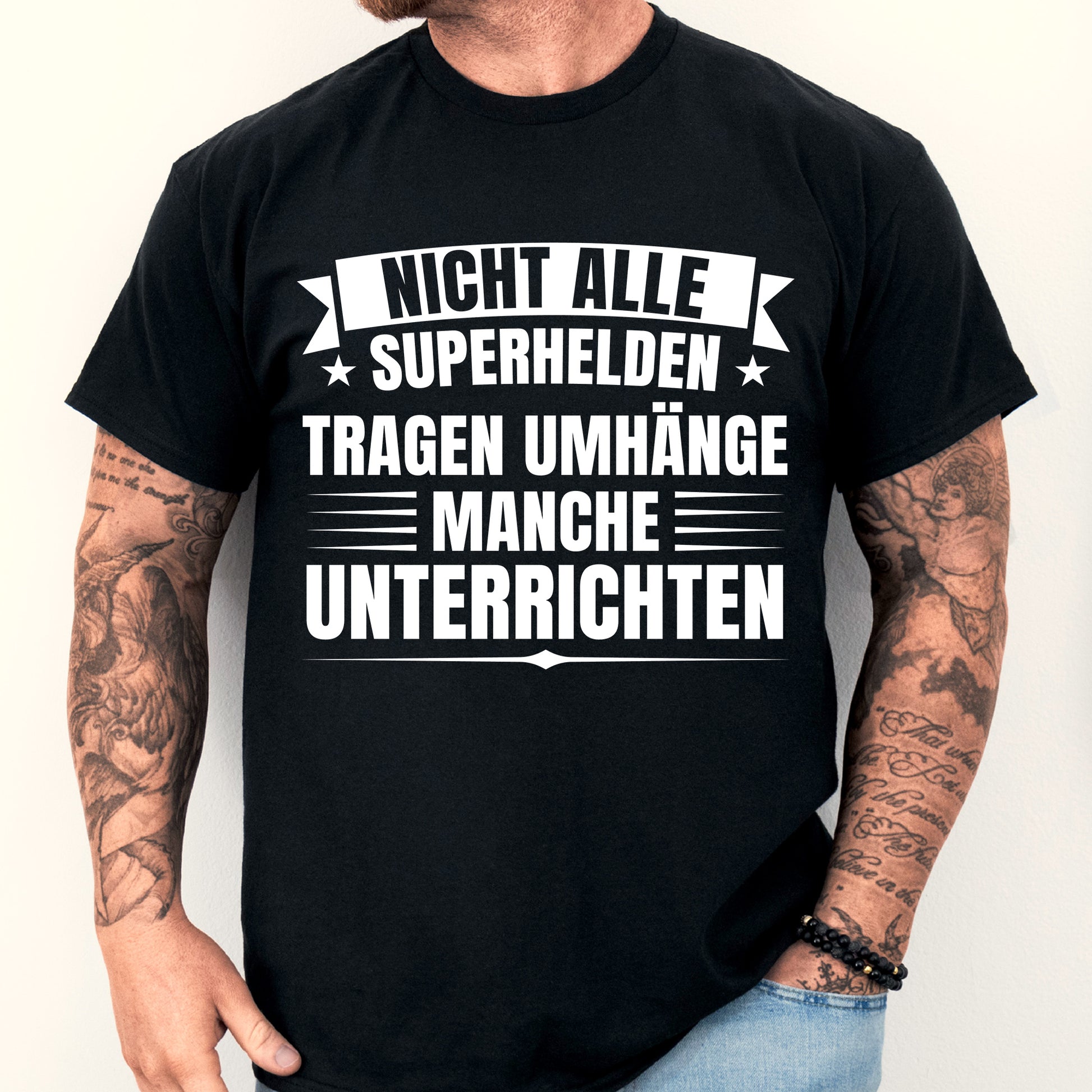 Mann trägt ein T-Shirt mit der Aufschrift "Nicht alle Superhelden tragen Umhänge, manche unterrichten" als Geschenkidee für Lehrer.