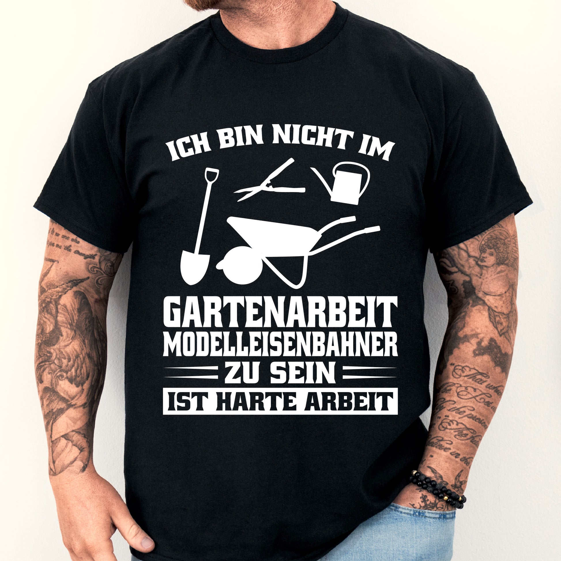 Mann trägt ein T-Shirt mit Garten- und Modelleisenbahn-Motiv.