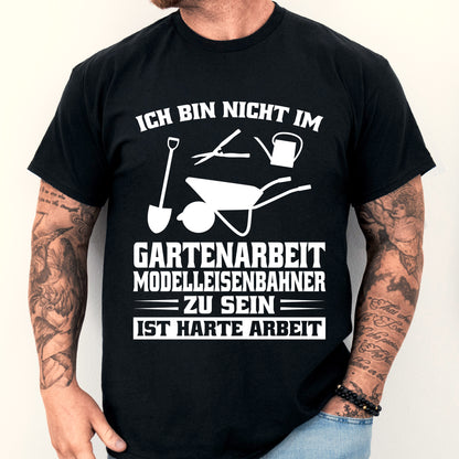 Mann trägt ein T-Shirt mit Garten- und Modelleisenbahn-Motiv.