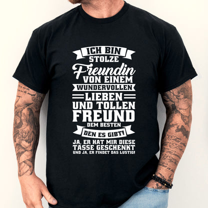 Mann trägt ein T-Shirt mit der Aufschrift "Ich bin stolze Freundin von tollen Freunden" und hält eine Tasse.