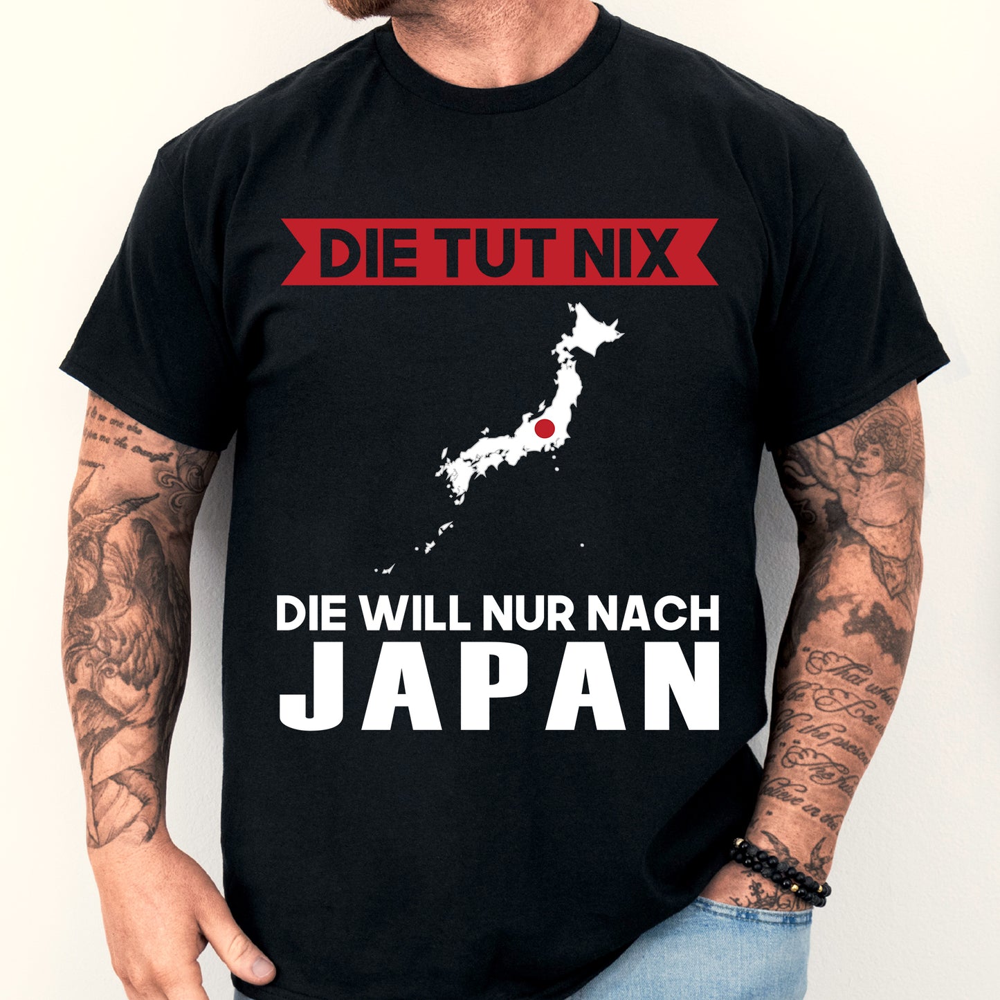 Mann trägt ein T-Shirt mit der Aufschrift 'Die tut nix Japanisch Geschenk' und einem japanischen Design.