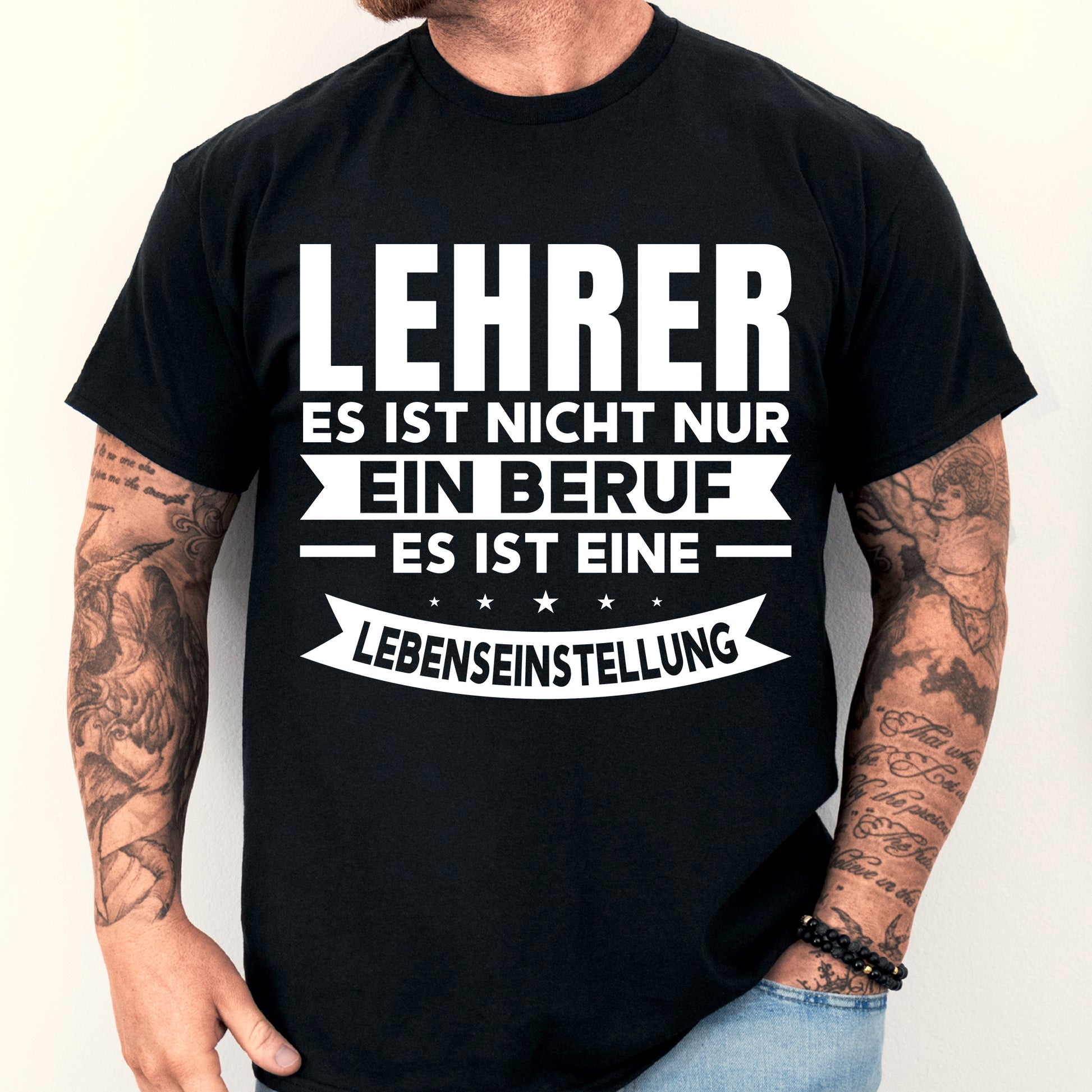 Mann trägt ein T-Shirt mit der Aufschrift "Lehrer Shirt | es ist nicht nur ein Beruf, eine Lebenseinstellung" als Geschenkidee für Lehrer und Lehrerinnen.