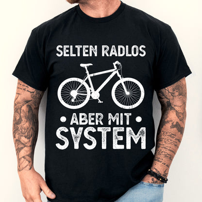Mann trägt ein T-Shirt mit Fahrrad-Design und dem Text "selten Radlos aber mit System".