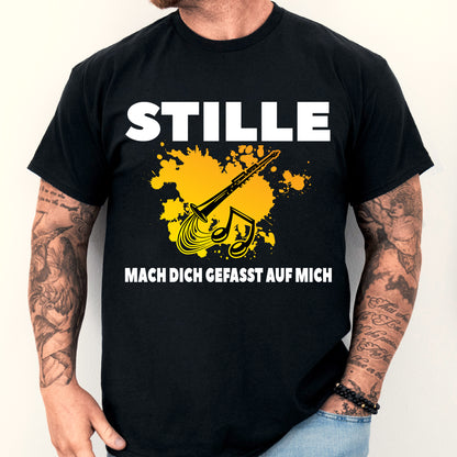 Mann trägt ein T-Shirt mit Klarinetten-Design und humorvollem Spruch über Musik.