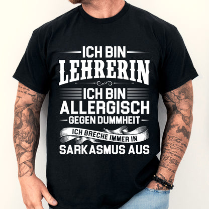 Mann trägt ein humorvolles Lehrer-Shirt mit der Aufschrift "Ich bin allergisch gegen Dummheit" als Geschenkidee für Lehrer.