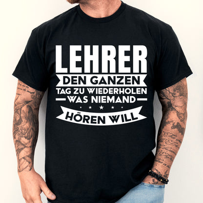 Mann trägt ein humorvolles Lehrer-Shirt mit Aufschrift über das ständige Wiederholen in der Schule.