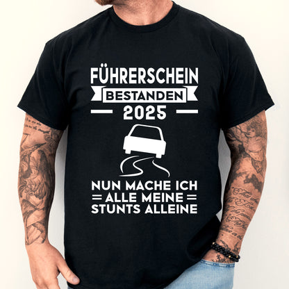 Design eines T-Shirts mit der Aufschrift "Führerschein bestanden 2025, nun mache ich alle meine Stunts alleine", abgebildet ist ein Mann.