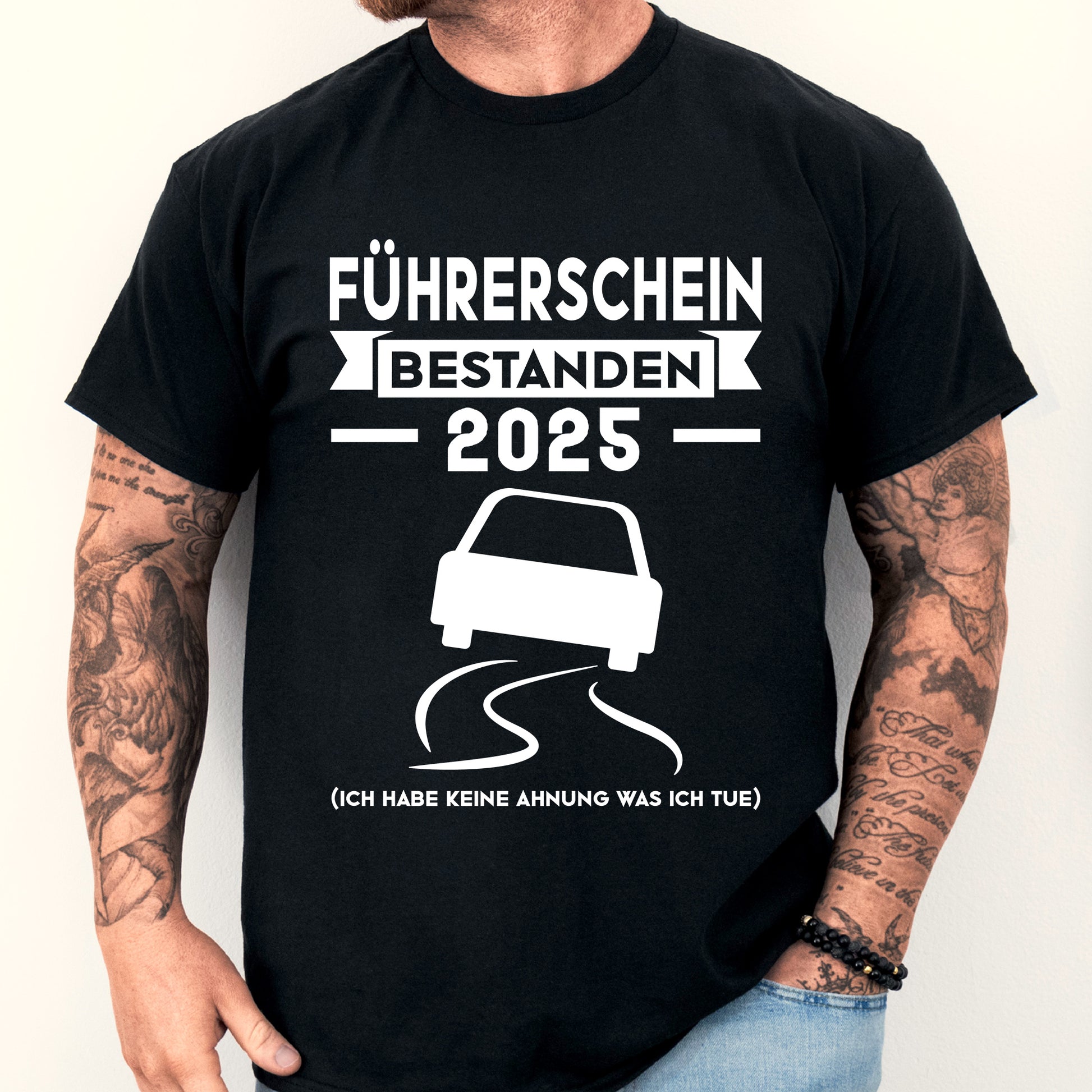 Mann trägt ein T-Shirt mit der Aufschrift "Führerschein bestanden 2025", ideal als Geschenk zur bestandenen Prüfung.