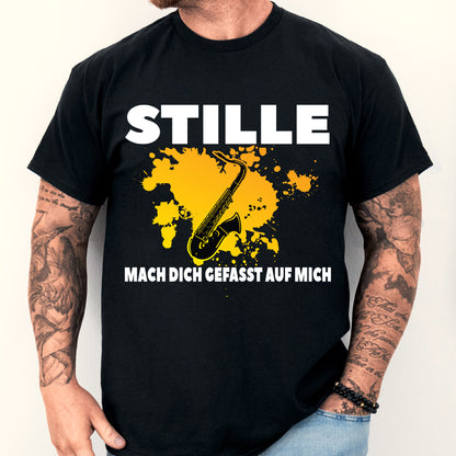 Mann trägt ein T-Shirt mit Saxophon-Design und dem Text "Stille mach dich gefasst auf mich", ideal als Geschenk für Musikliebhaber und Instrumentenspieler.