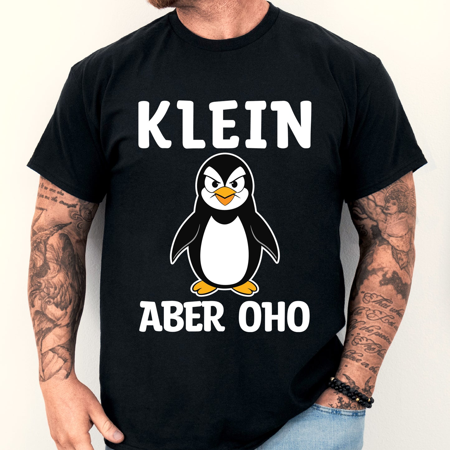 Design eines T-Shirts mit der Aufschrift "Klein aber oho" und einem stilisierten Mann.